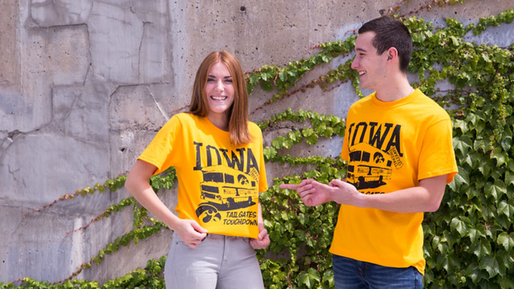 Two students laughing wearing Hawkeye gold shirts