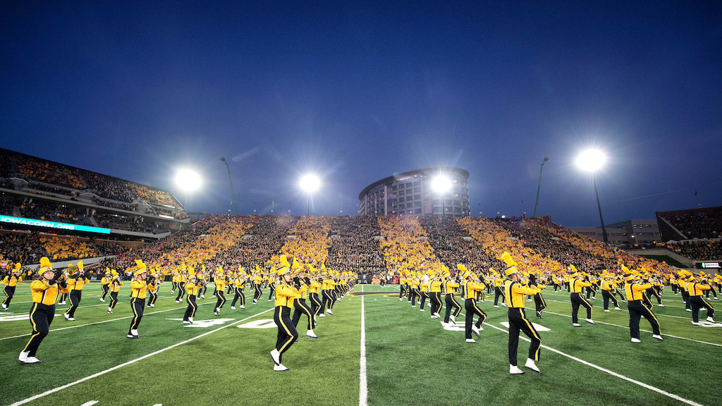 Marching band playing music and marching on Kinnick stadium