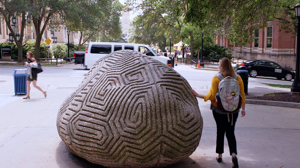 Person walking and touching the brain rock